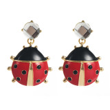 Unique red crystal ladybug earrings with niche design