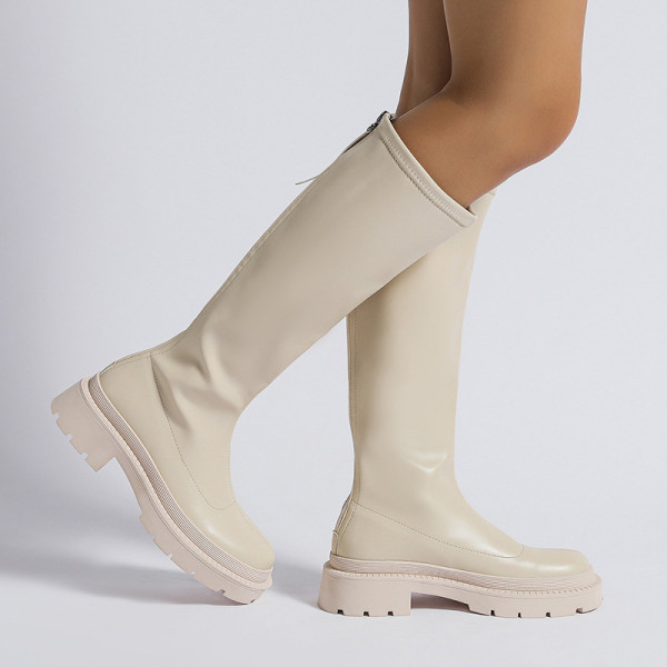 Small white boots with thick soles and high shafts are thinner than knees