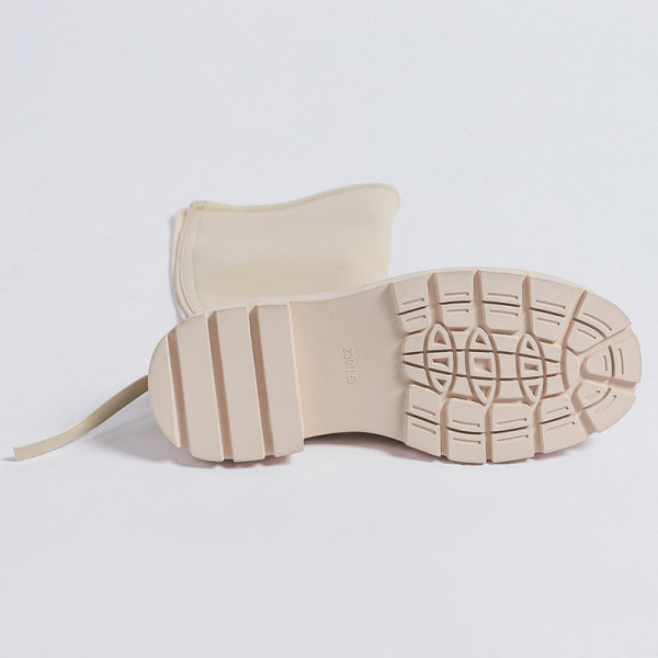 Small white boots with thick soles and high shafts are thinner than knees